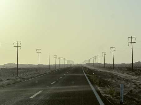 Sand blowing across highway and dirty sky